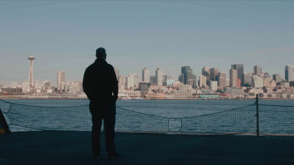 Ed Pierson stands looking at a city skyline in Flight Risk