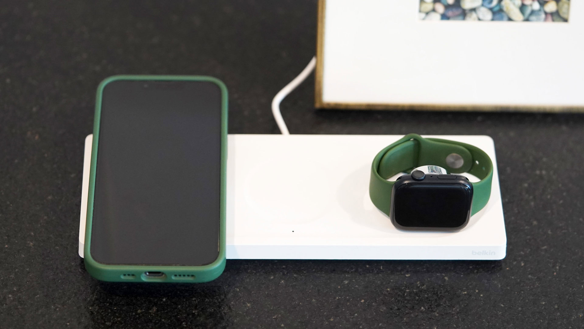 A Belkin BoostCharge Pro 3 in 1 Wireless Charging Pad charges an iPhone and an Apple Watch.