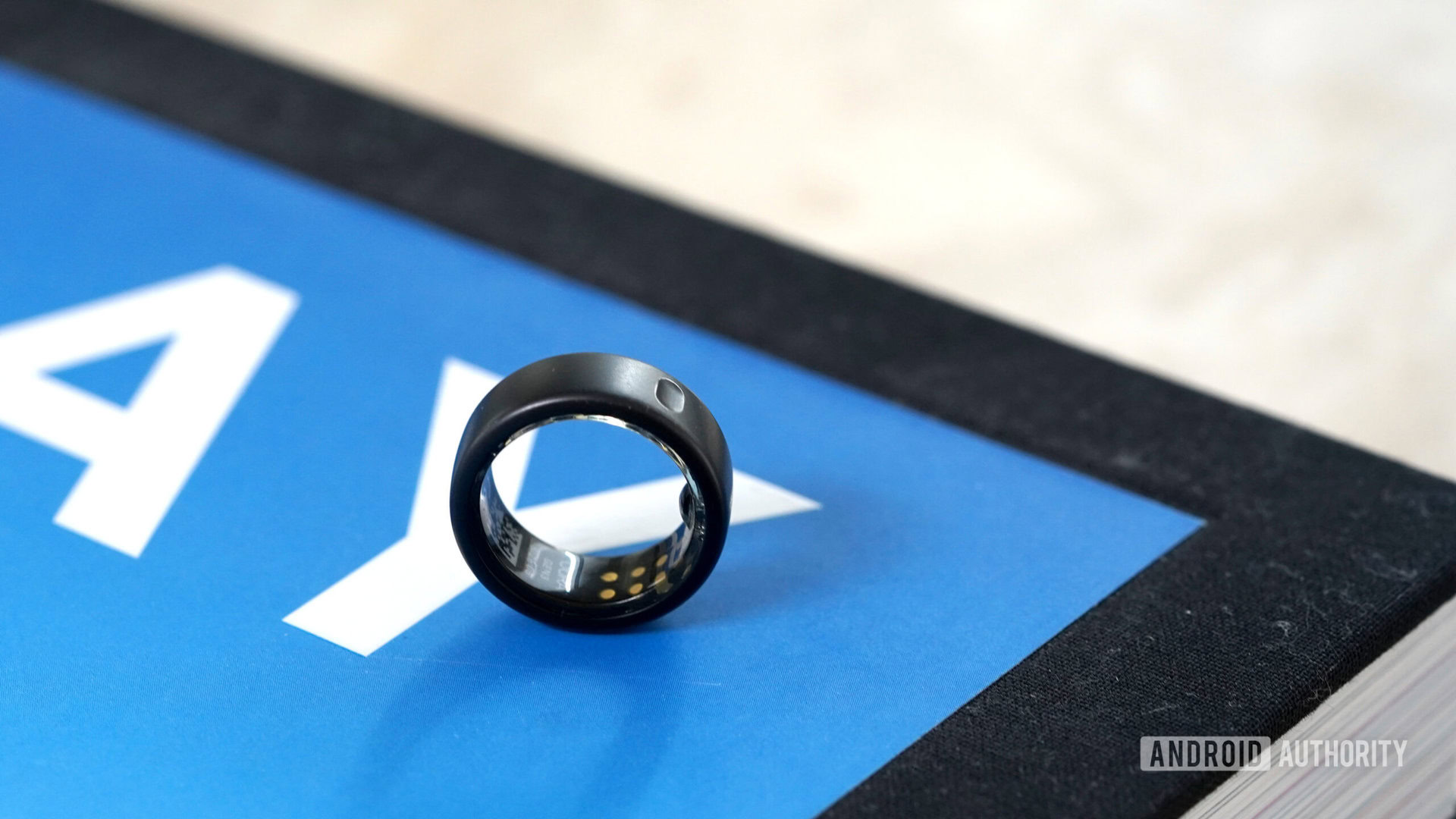 An Oura Ring 3 rests on a coffee table book.