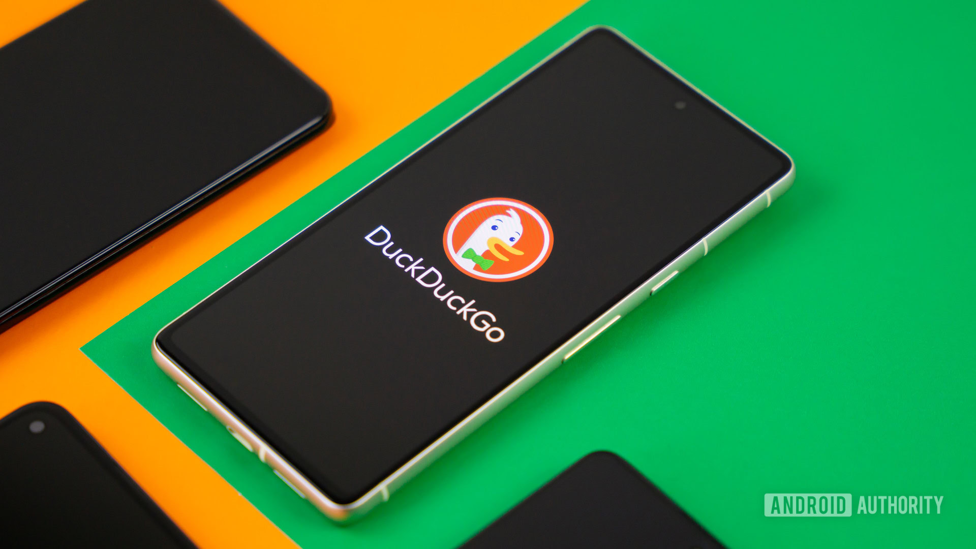 Stock photo of DuckDuckGo logo on smartphone next to other phones 2