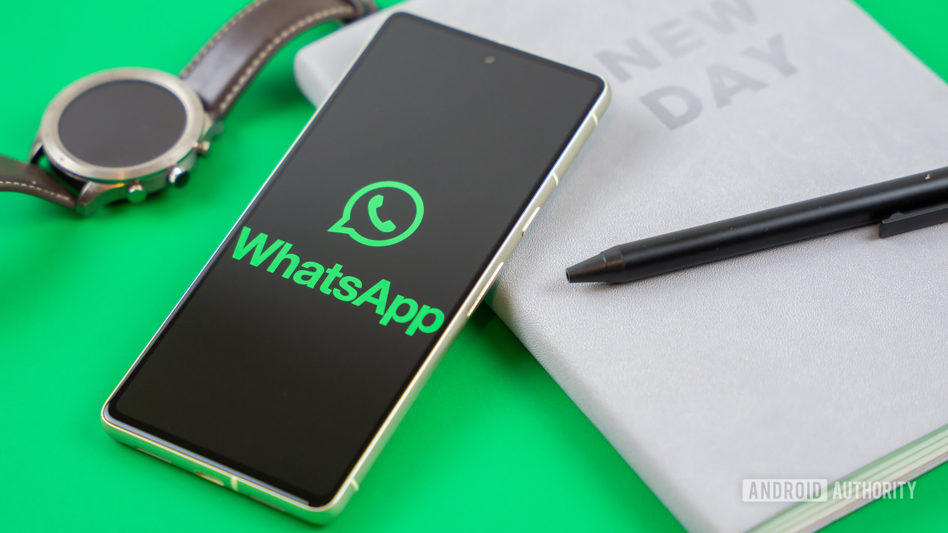 Logotipo de WhatsApp en el teléfono inteligente junto a los accesorios cotidianos Foto de stock 1