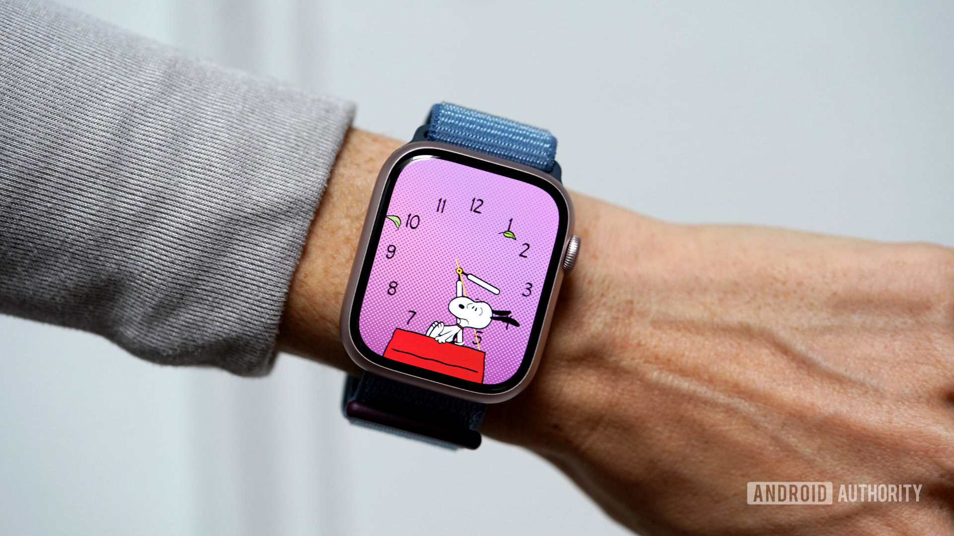 An Apple Watch Series 9 displays the Snoopy watch face.