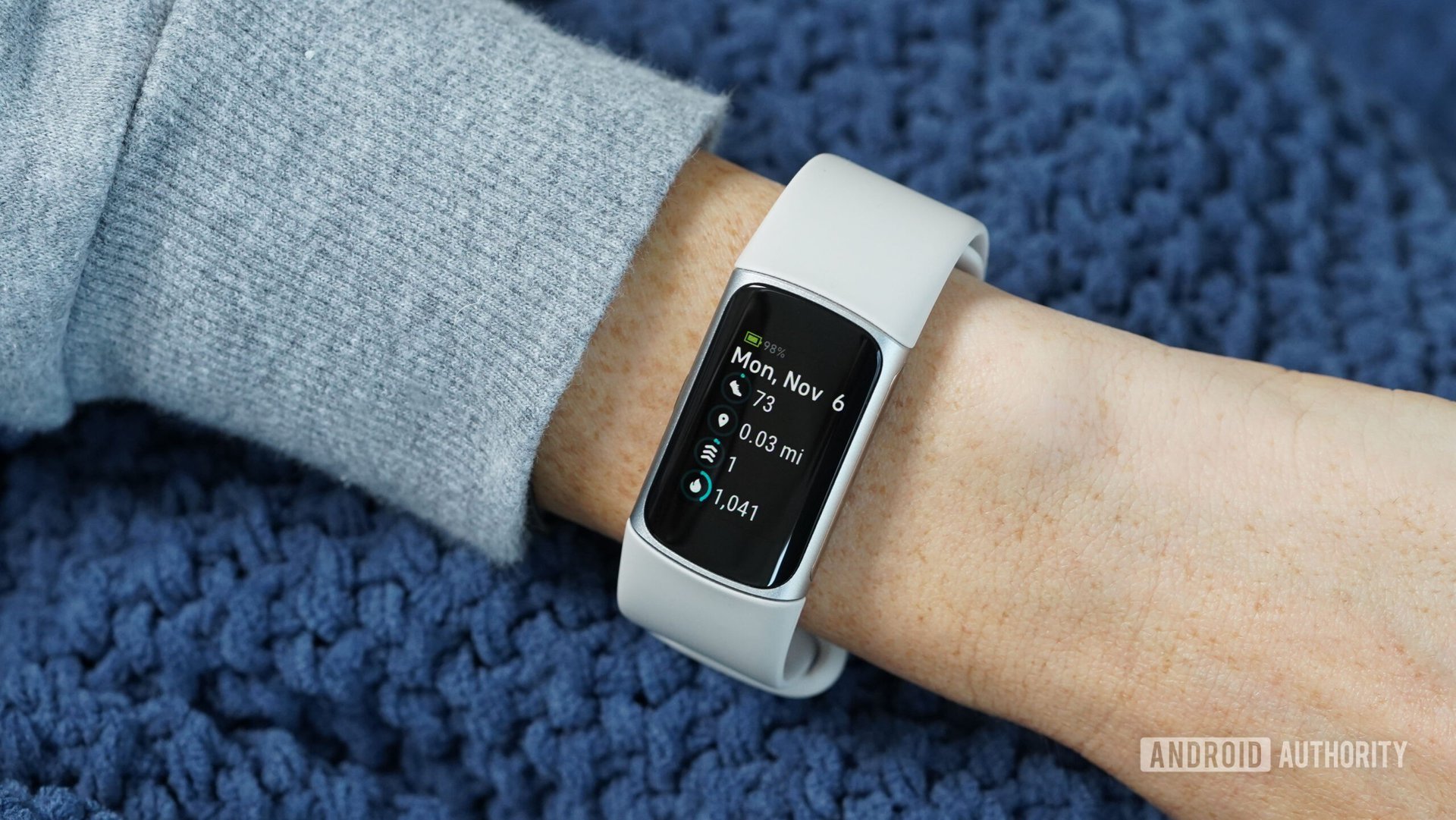 A Fitbit Charge 6 displays a users activity stats.