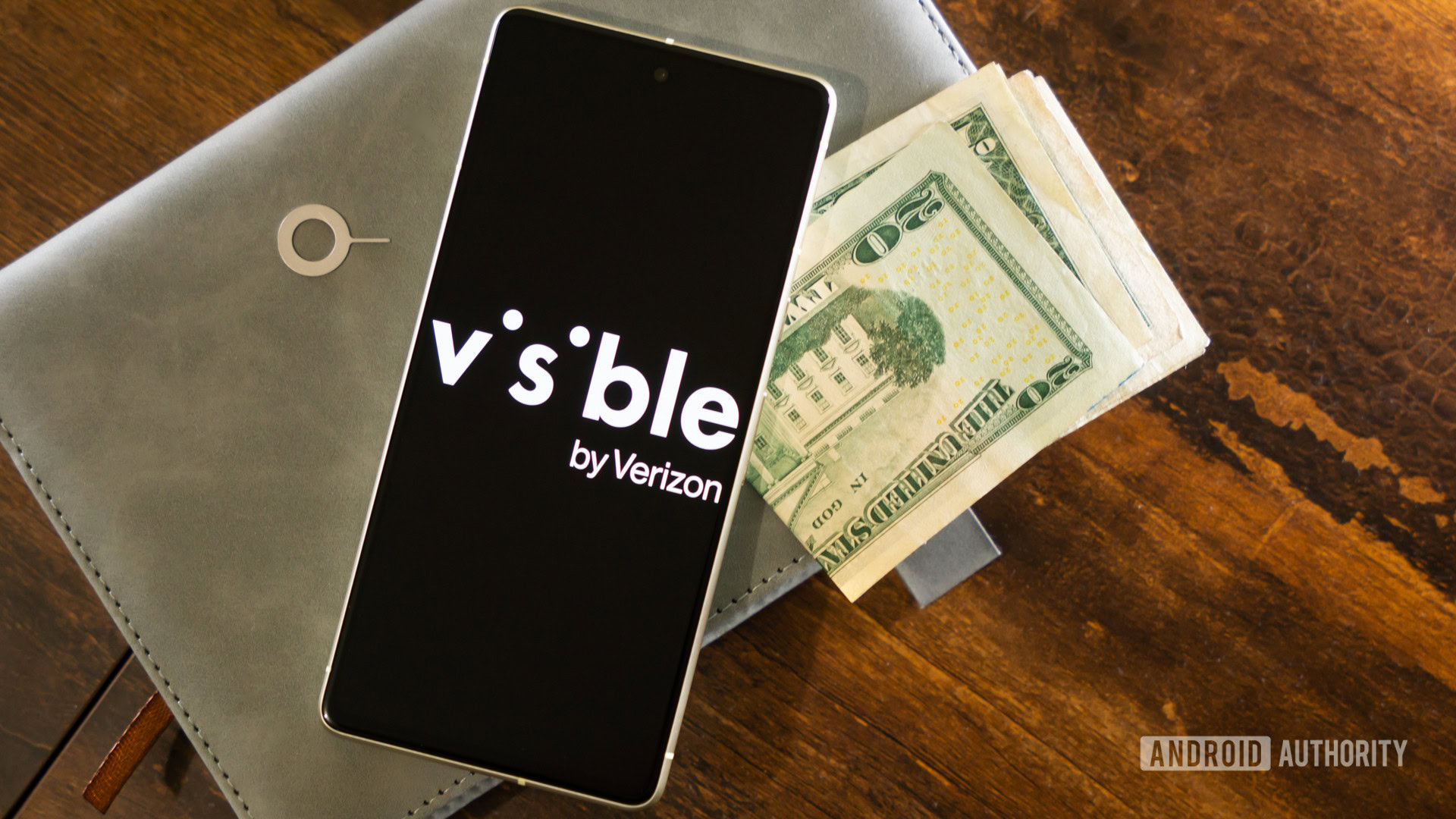 Visible by Verizon logo on smartphone, next to money and SIM ejector tool (2)