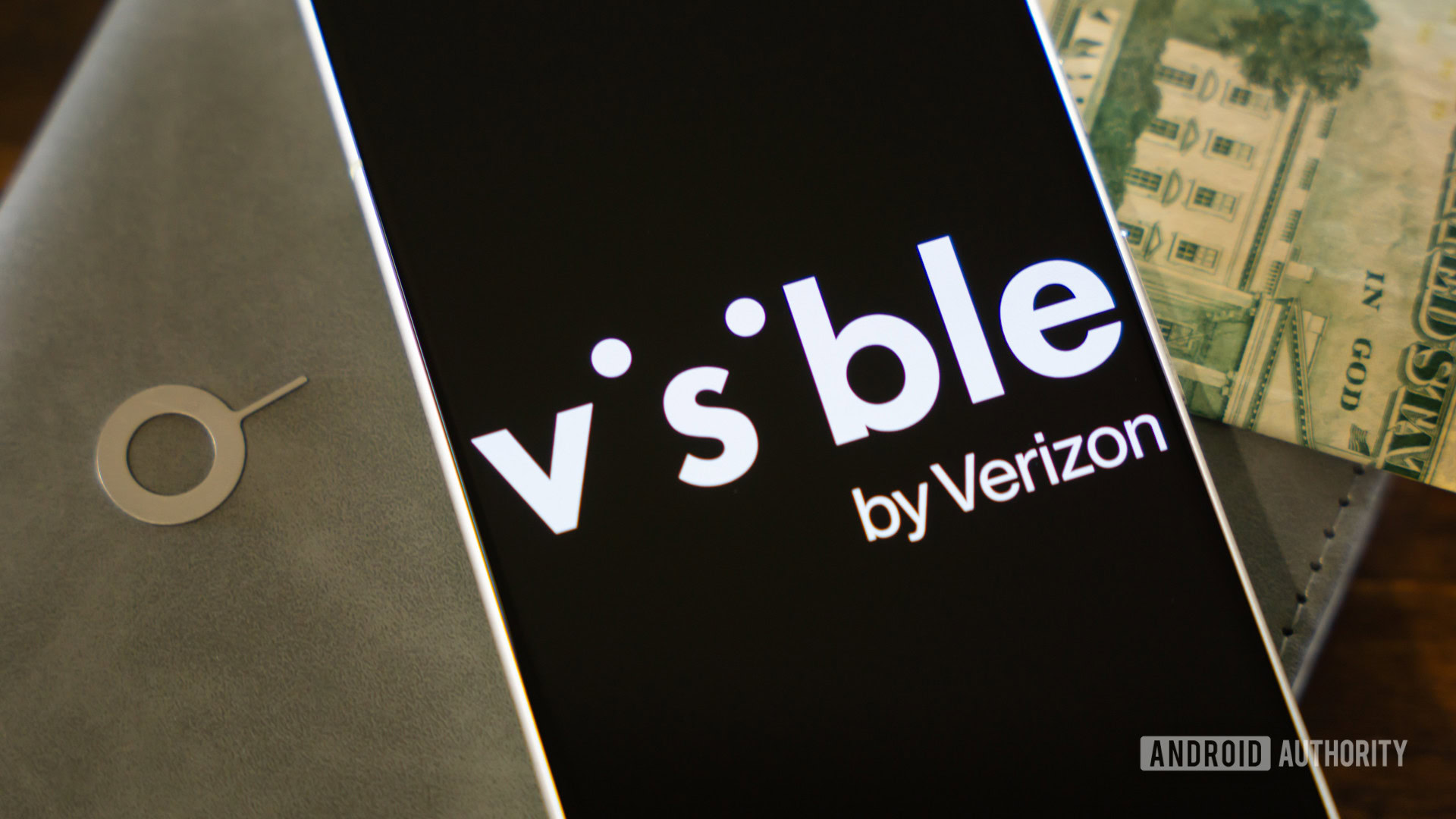 Visible by Verizon logo on smartphone, next to money and SIM ejector tool (3)