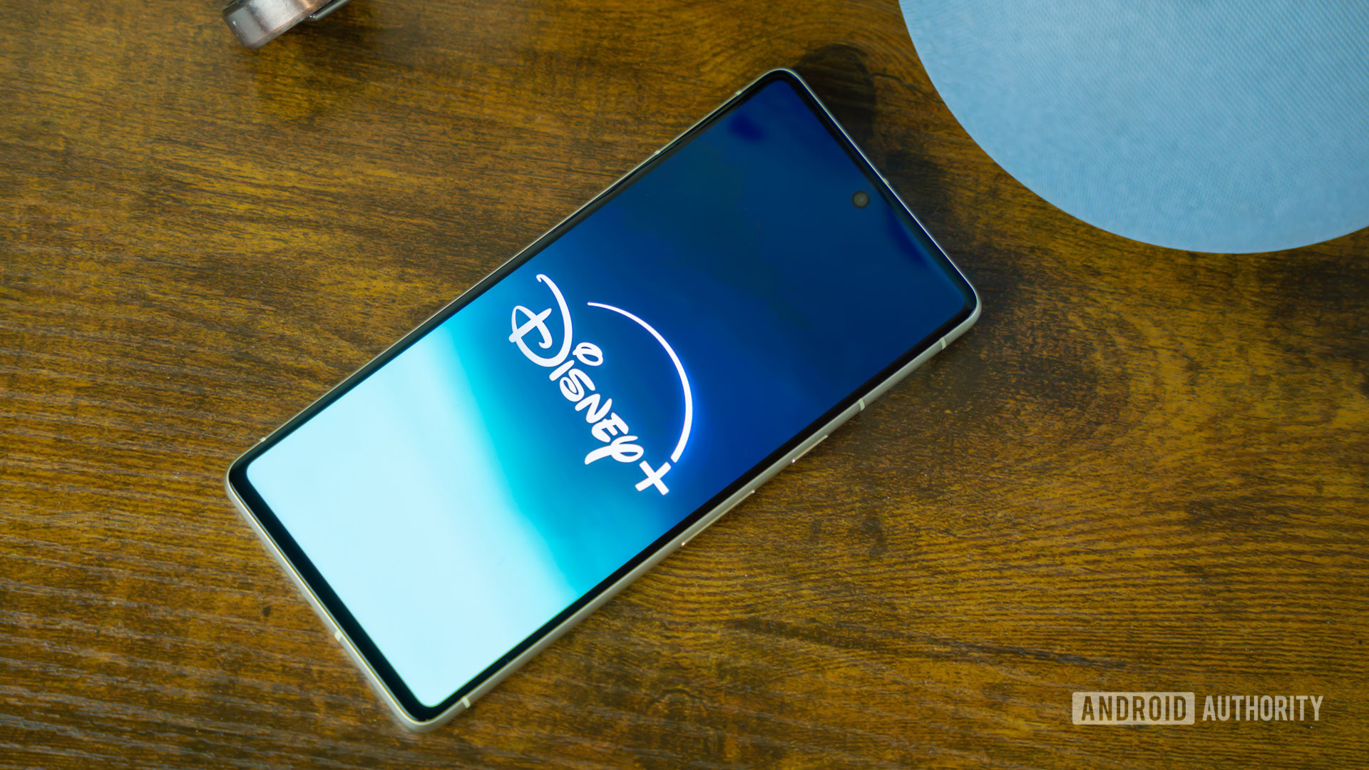 Disney Plus logo on smartphone laying on side table stock photo (1)