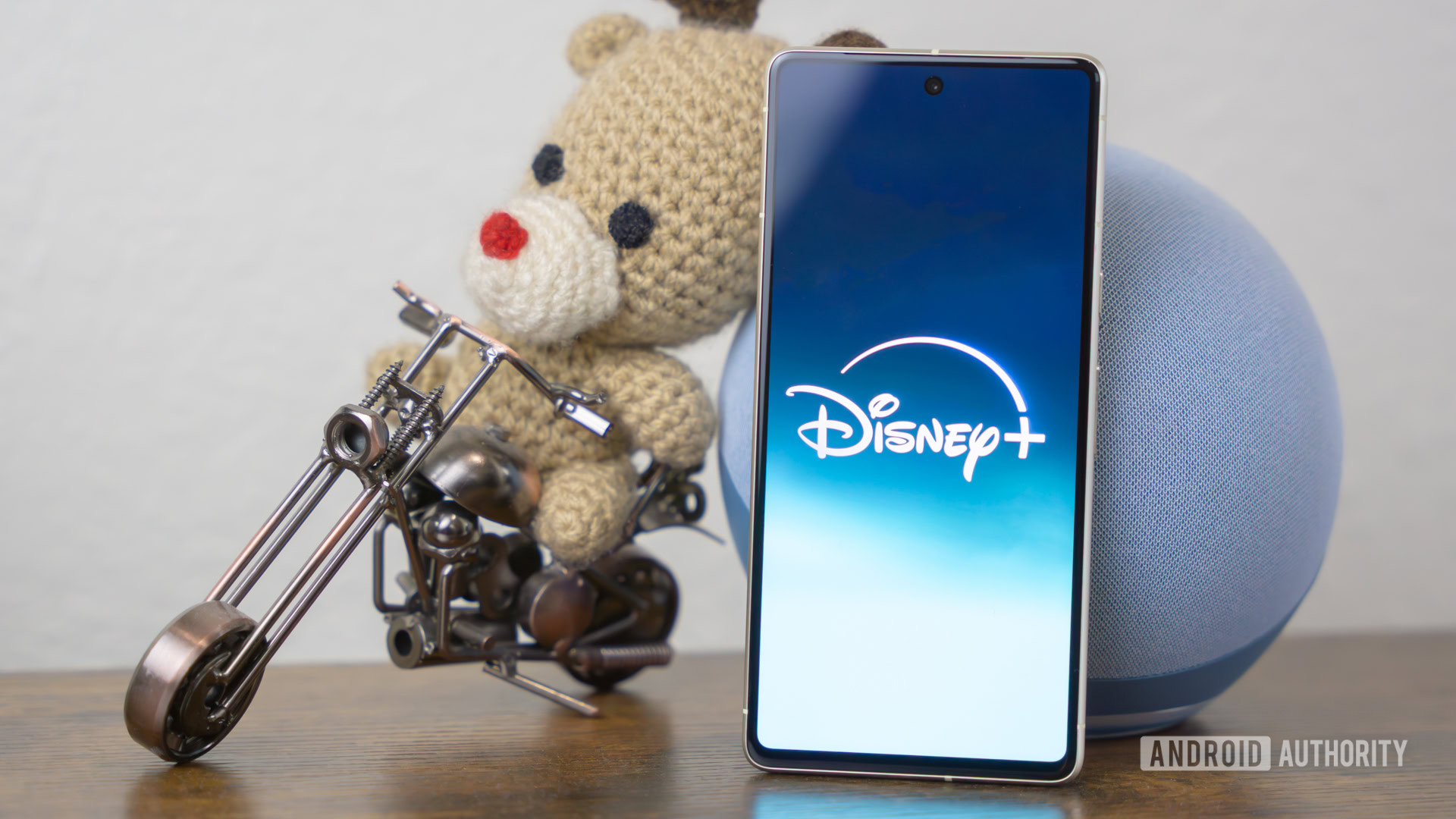 Disney Plus logo on smartphone laying on side table stock photo (3)
