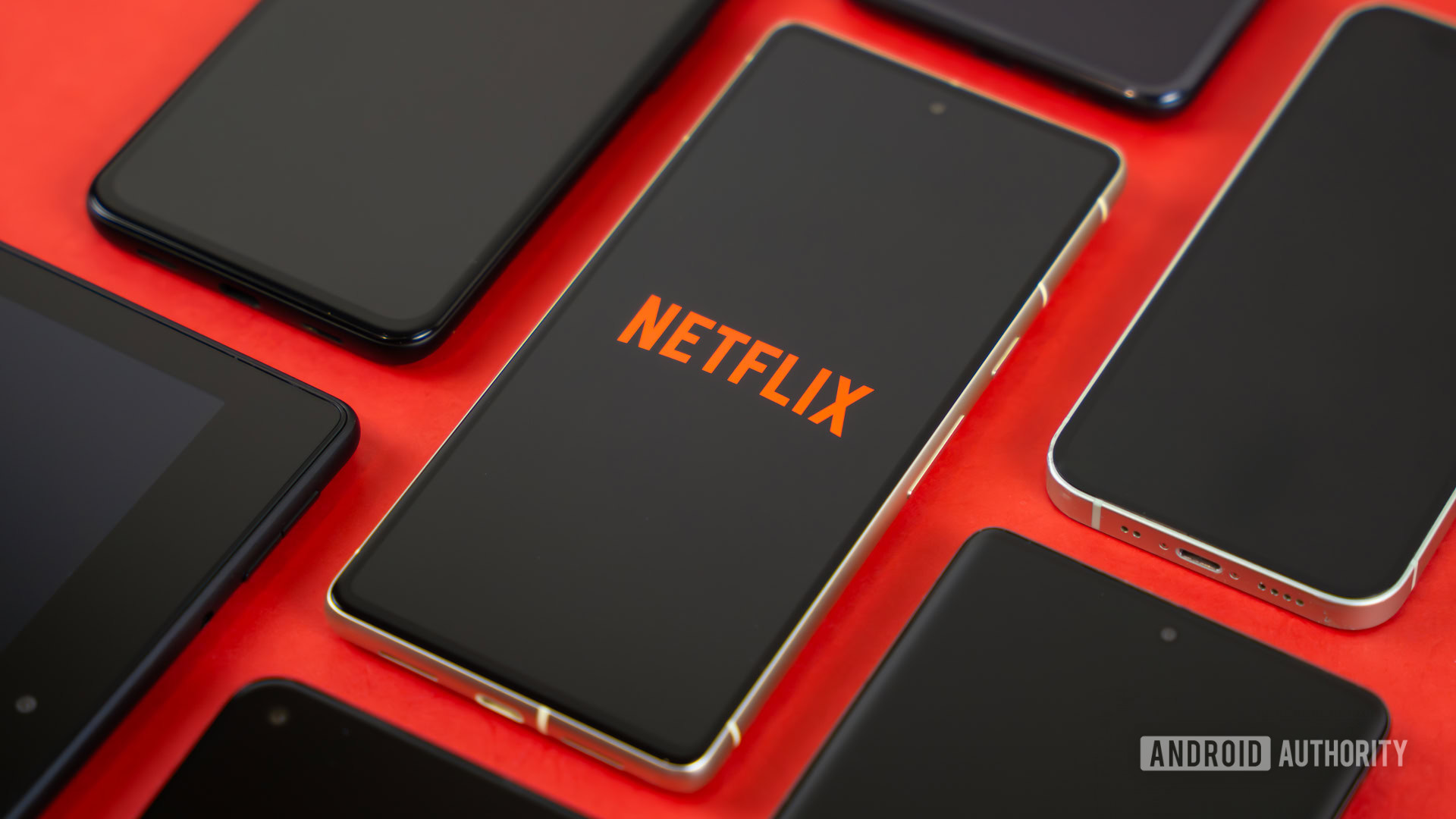 Netflix logo on smartphone, next to other devices stock photo (3)