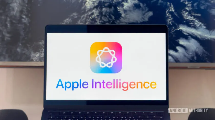 Un ordenador portátil que muestra el logotipo de Apple Intelligence en la pantalla. El logotipo consiste en un ícono abstracto con una forma geométrica en el centro, acompañado del texto "Apple Intelligence" en la parte inferior, escrito con un degradado de colores que va del naranja al azul. Al fondo, se puede ver una pantalla con una imagen del espacio, destacando la Tierra parcialmente iluminada.