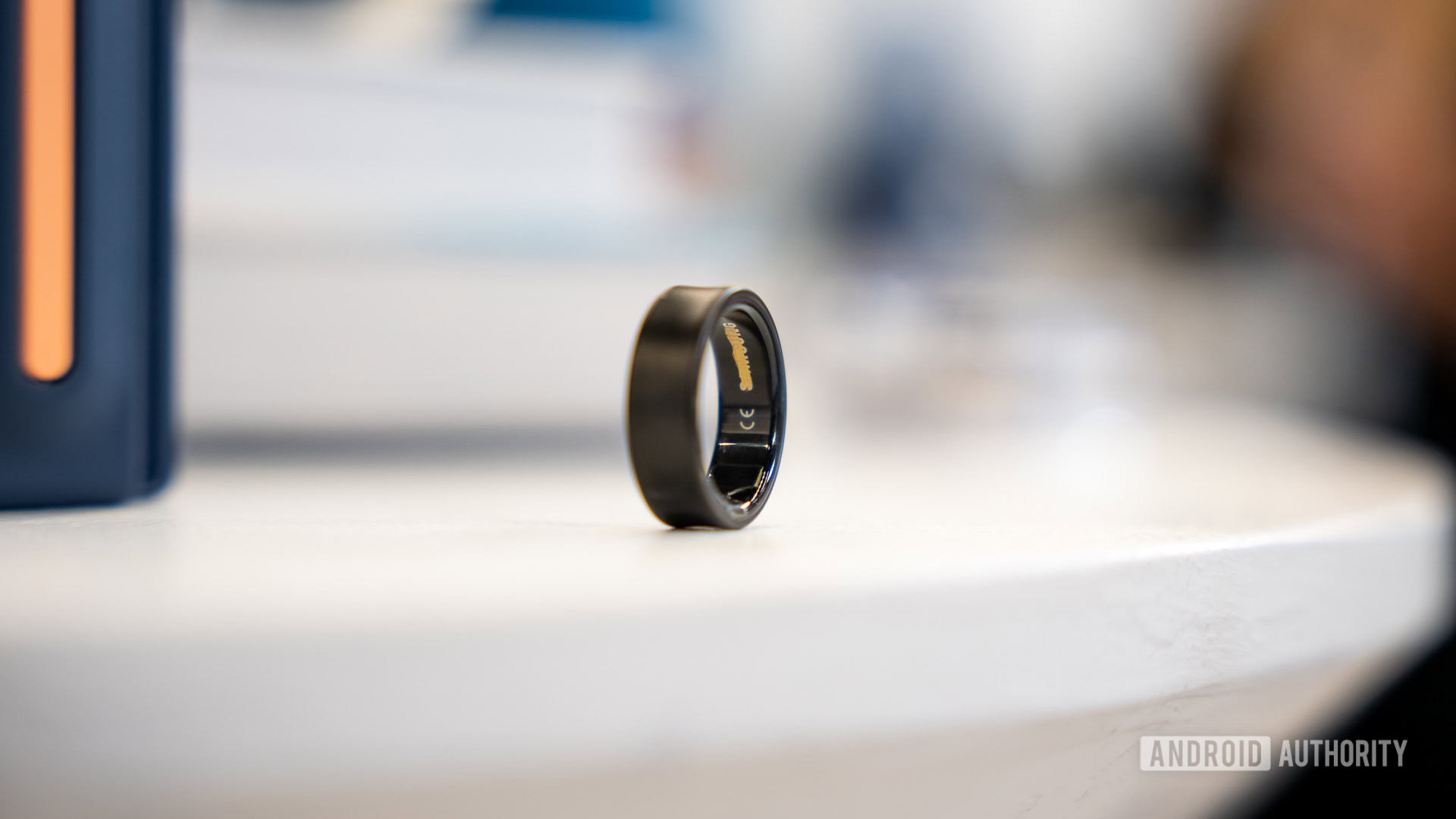 A Samsung Galaxy Ring in a Black Titanium finish rests on a table.