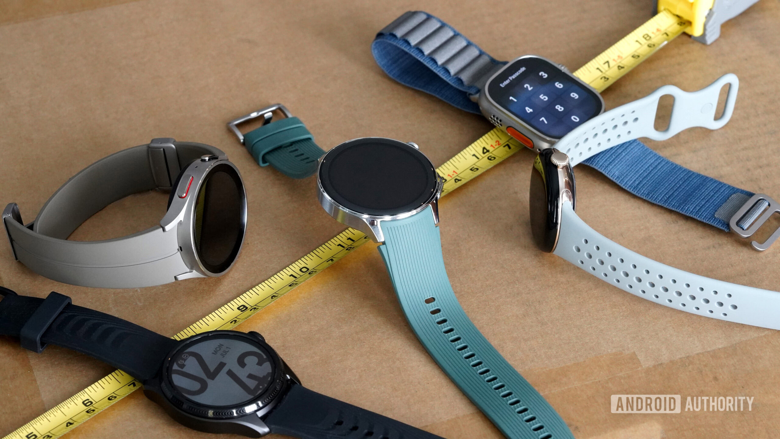 A variety of smartwatches rest along a measuring tape, highlight assorted case sizes.