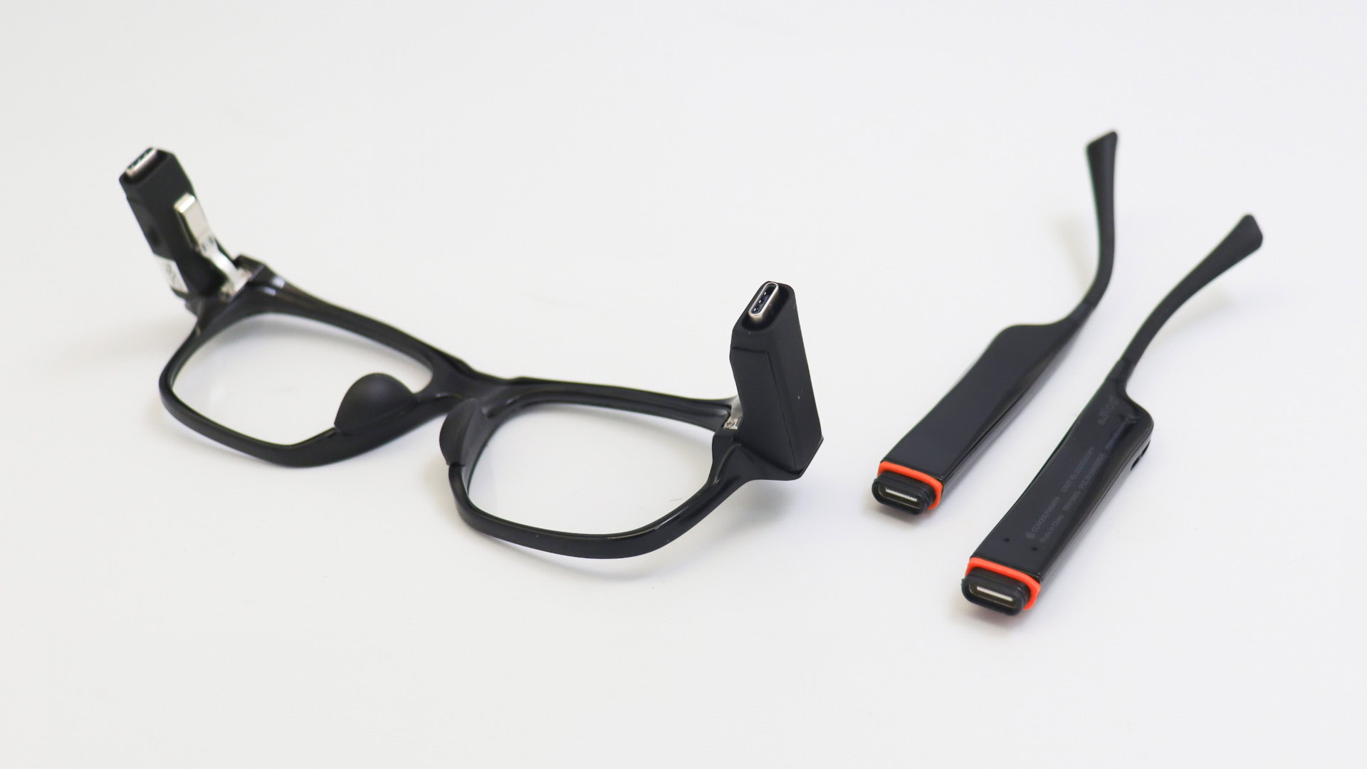 Solos AirGo Vision smart glasses placed on white table with stems detached.