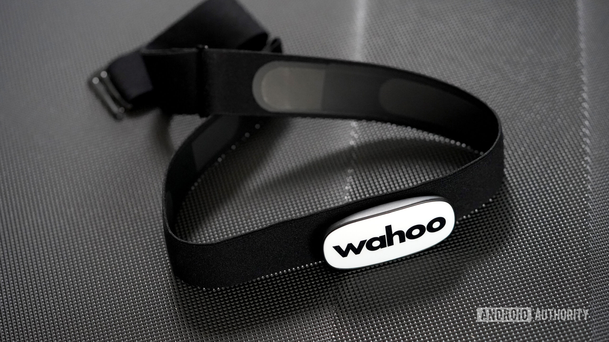 A Wahoo Trackr Heart Rate monitor rests on a treadmil after a user's workout.