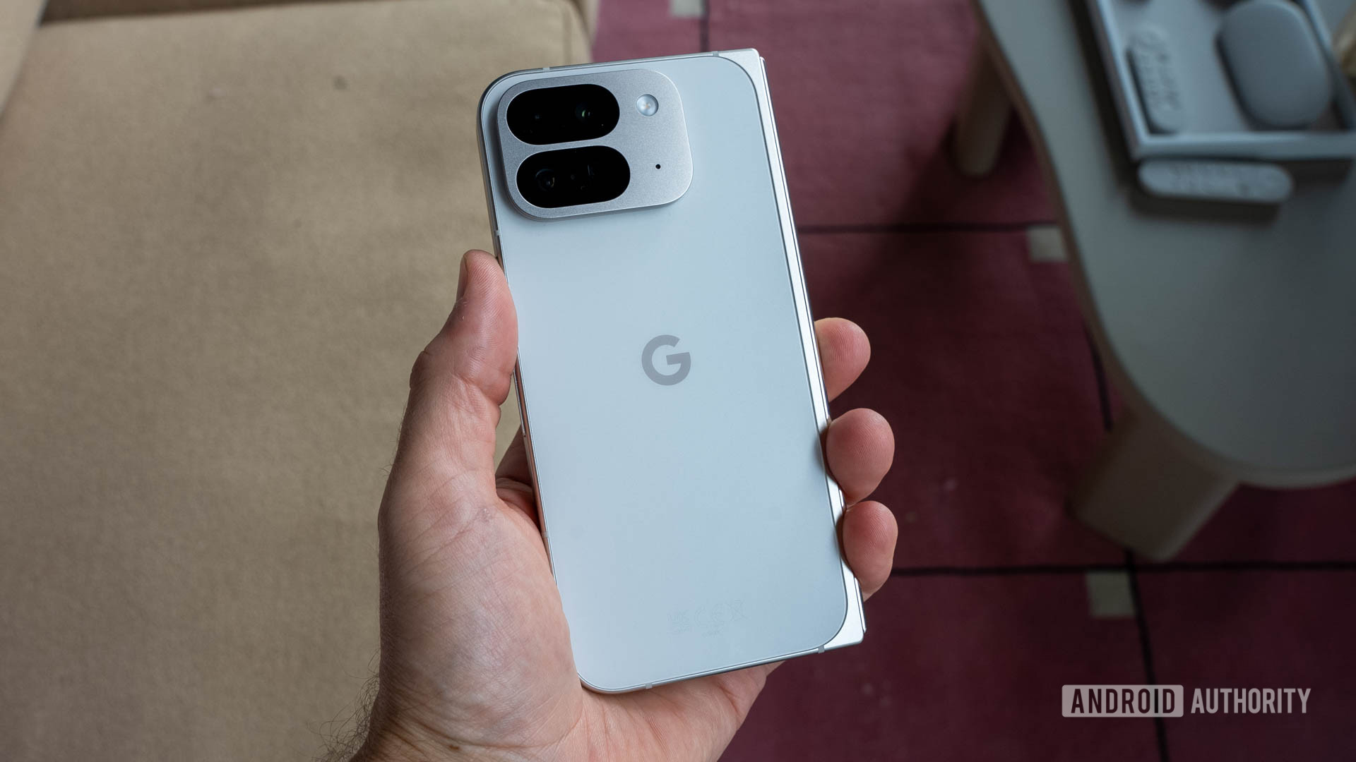 Google Pixel 9 Pro Fold in Porcelain color held in person's left hand with back facing viewer