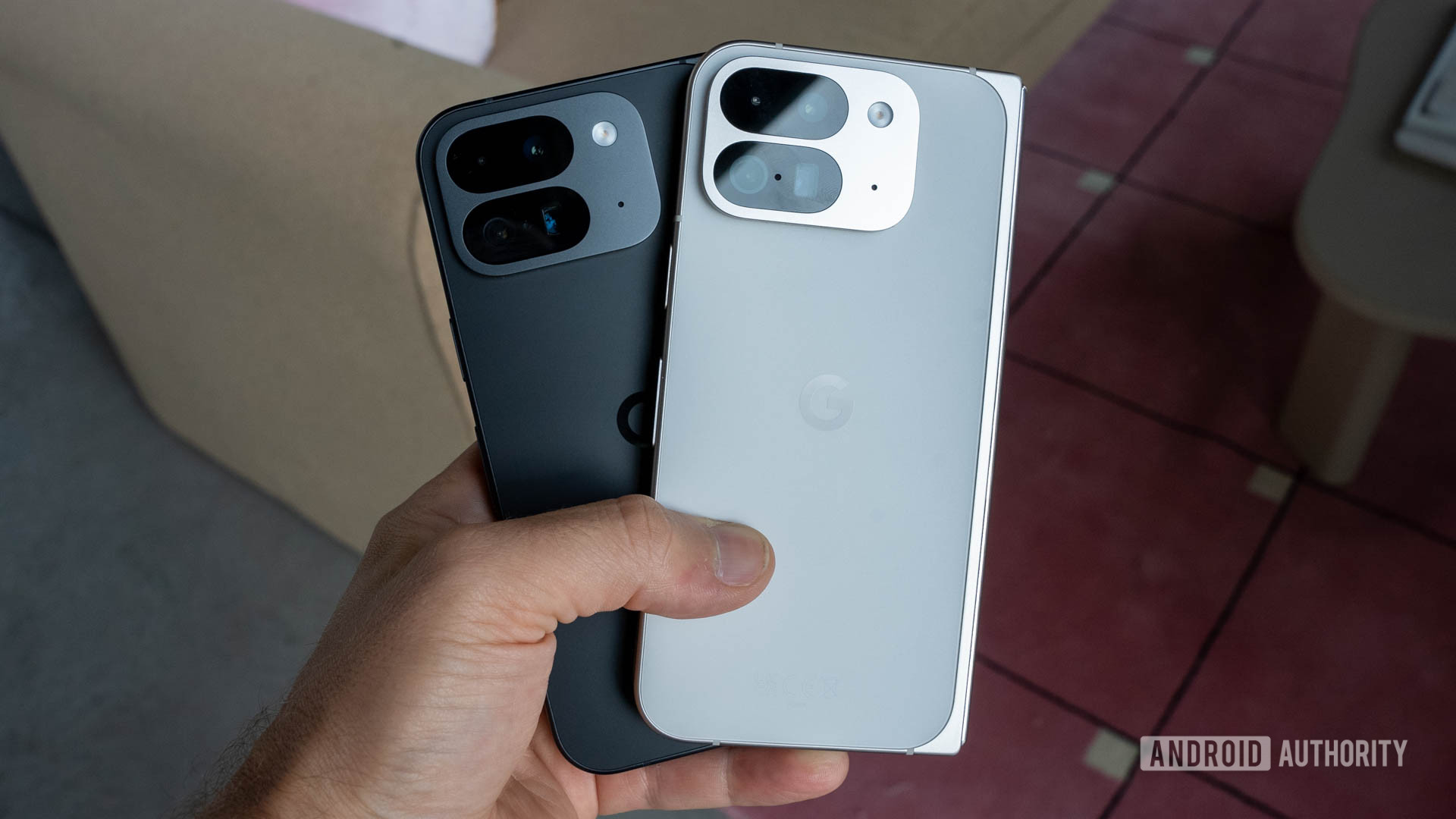 Google Pixel 9 Pro Fold in both Obsidian and Porcelain colors held in a person's left hand