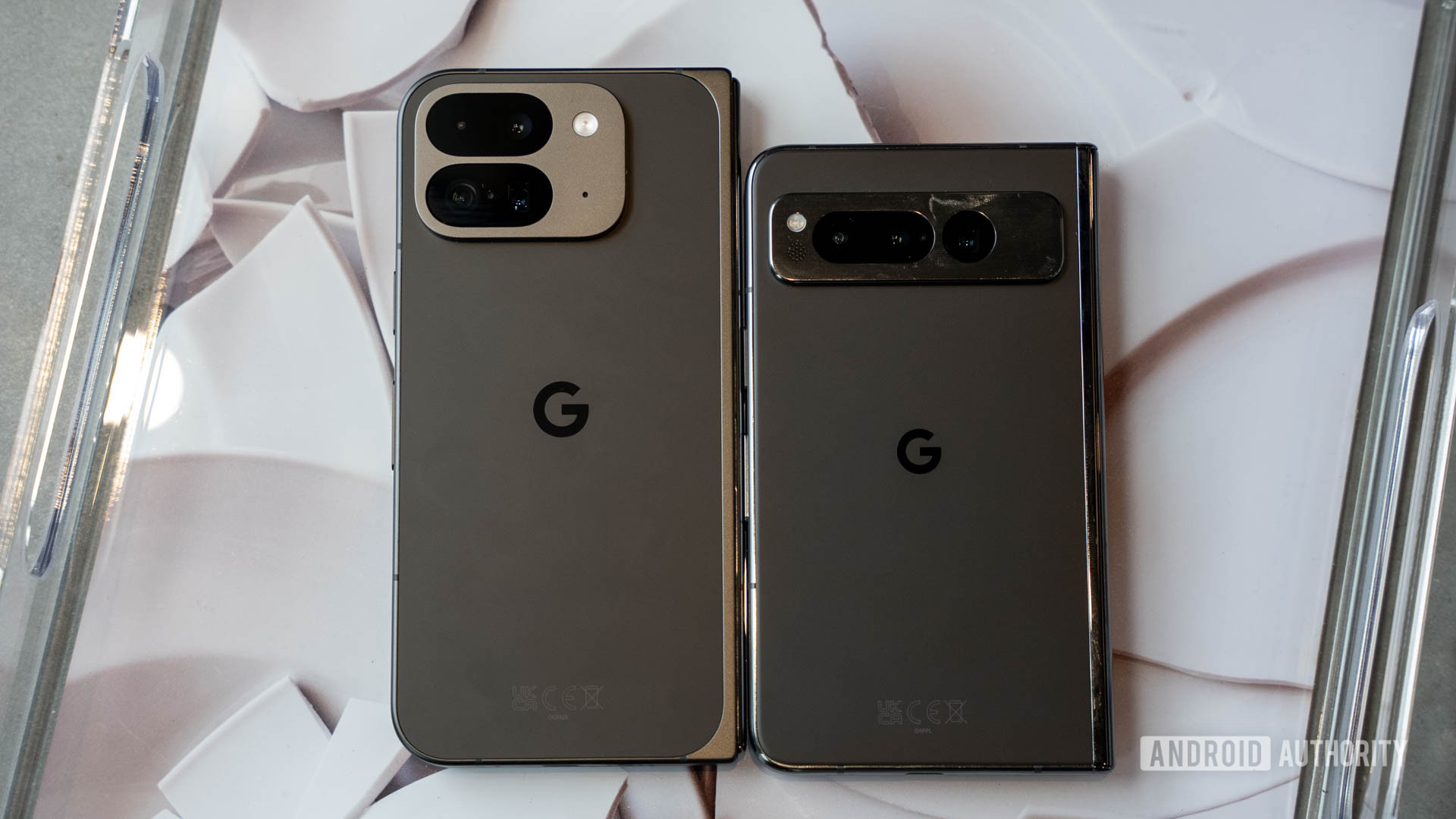 Google Pixel 9 Pro Fold next to Google Pixel Fold resting on table tray showing backs of both phones