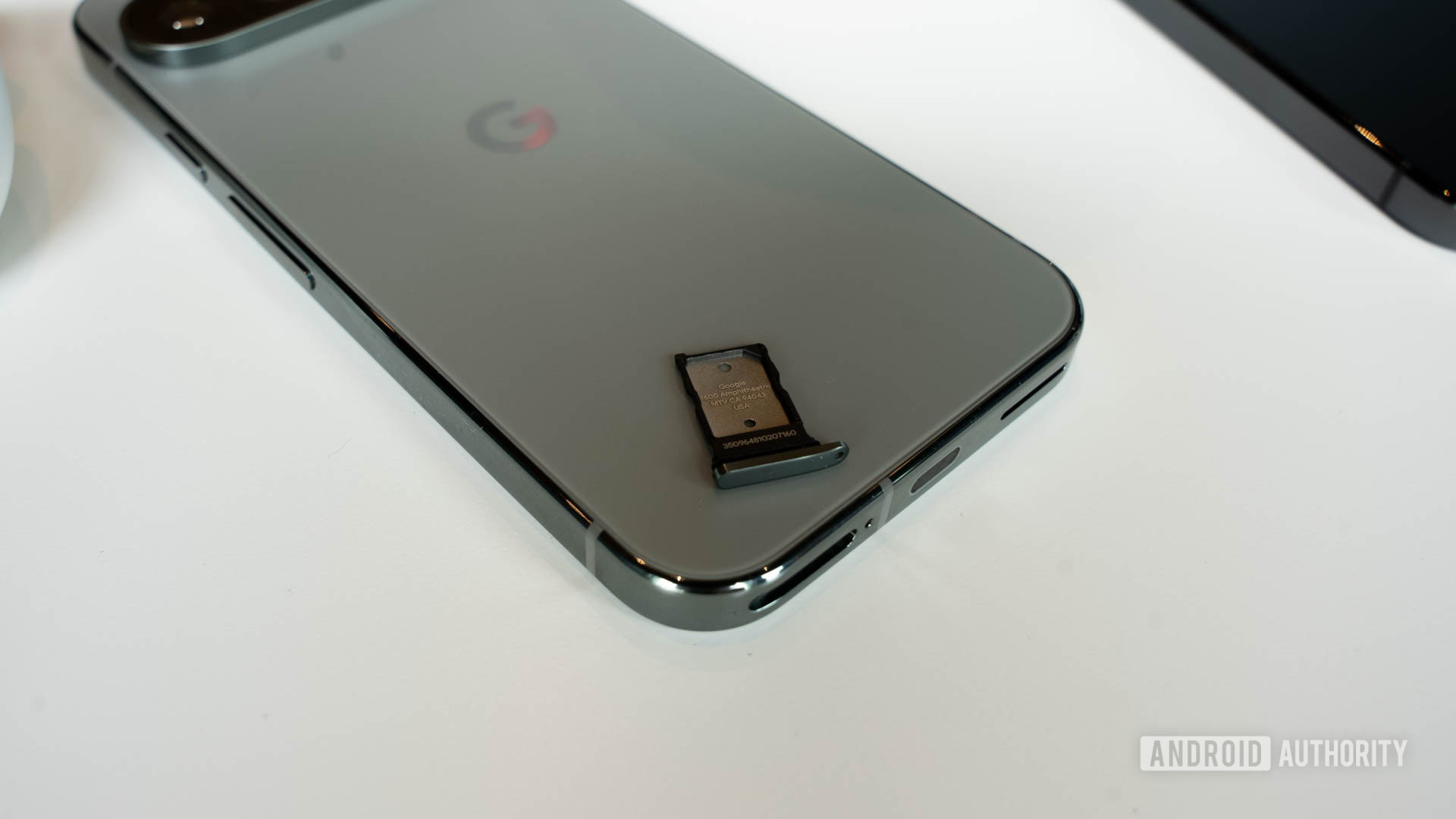 Google Pixel 9 Pro in hazel with its SIM tray on its back