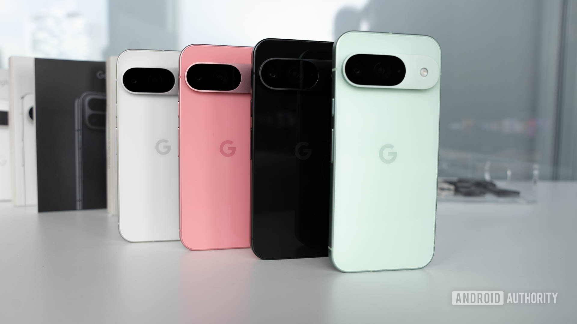 Google Pixel 9 in four colors standing on a table in a row formation