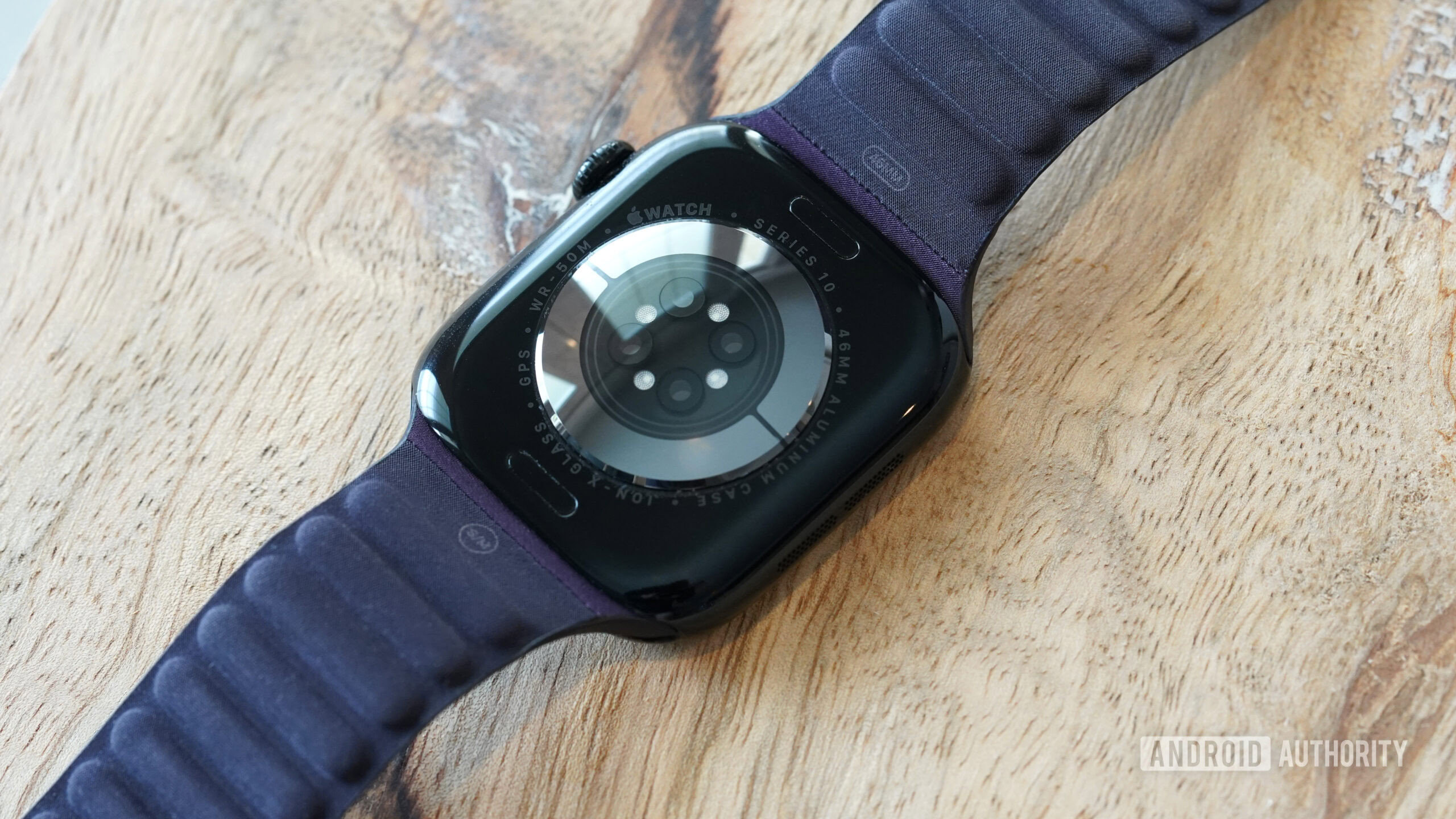 An Apple Watch Series 10 face down display the device's sensors.