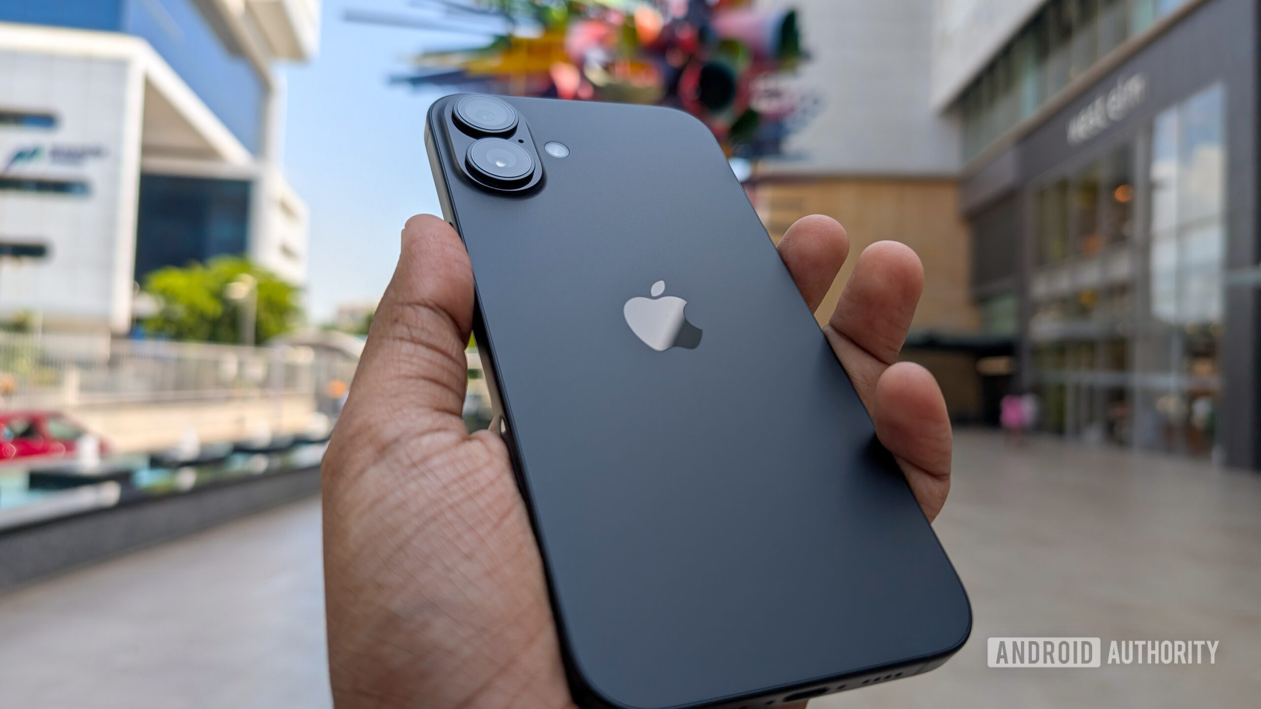 Apple iPhone 16 Plus in black color held out in hand