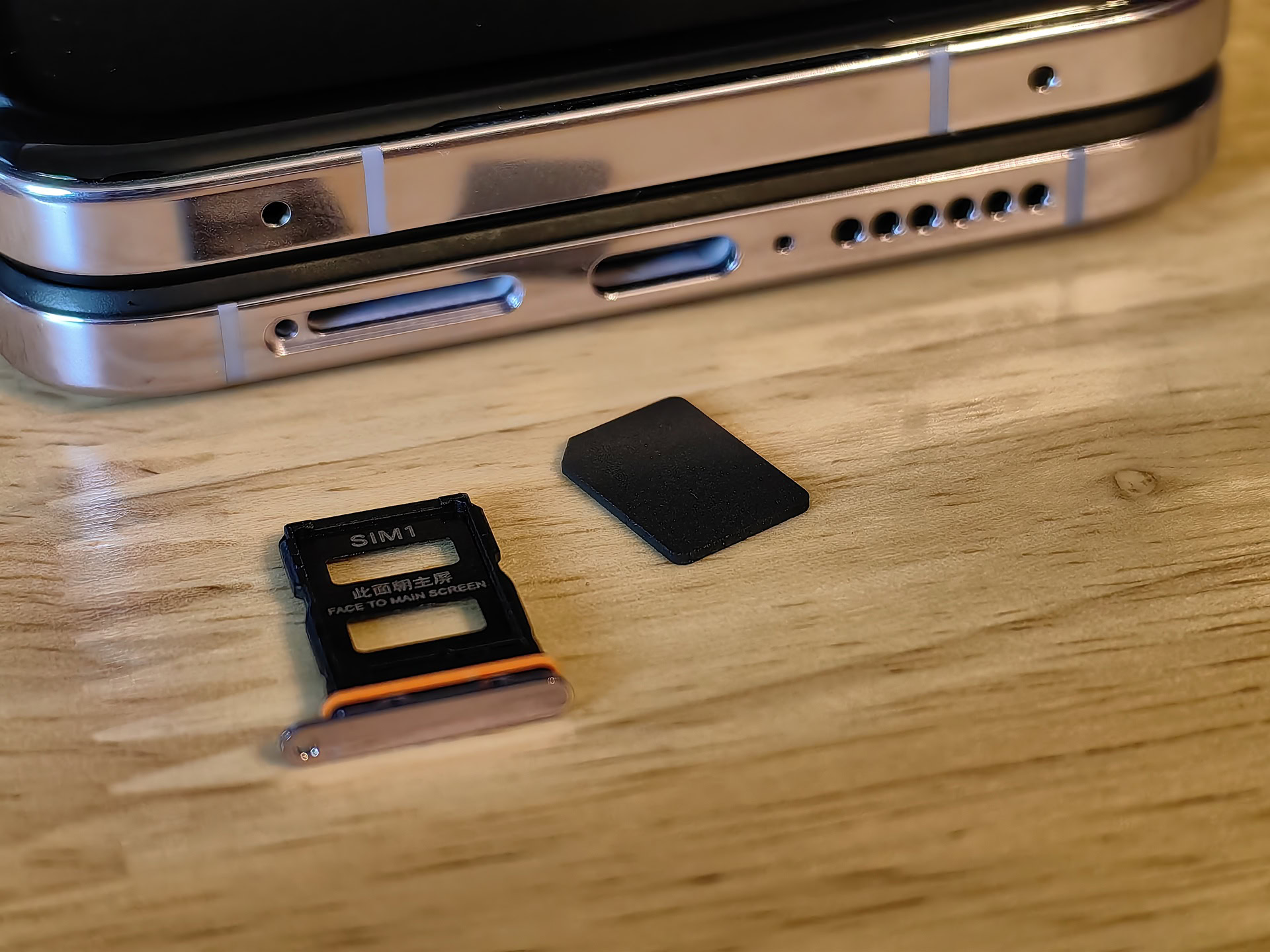 Front of JMP eSIM Adapter next to Xiaomi MIX Flip