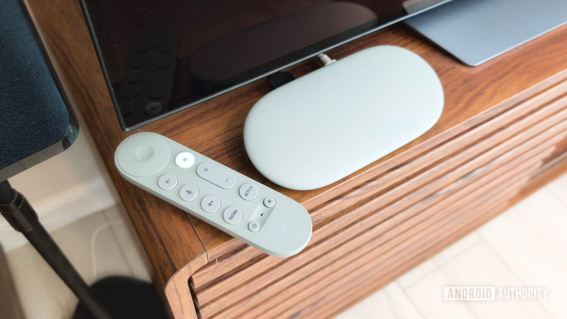 Google TV Streamer dengan remote di TV Console Hero