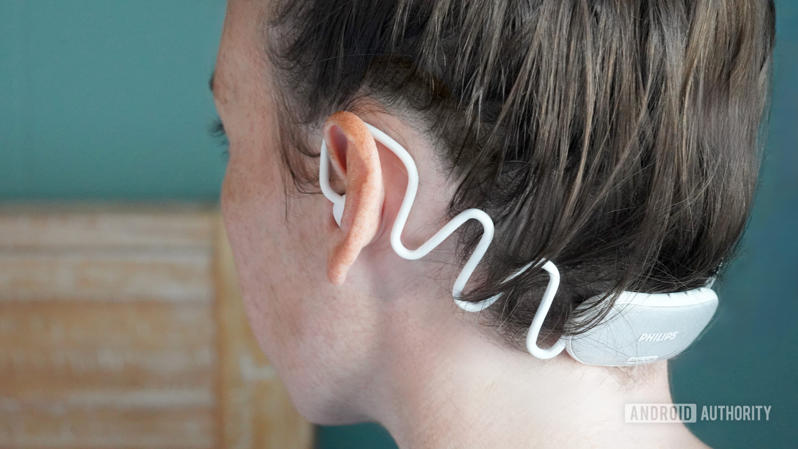 A user wears a pair of Philips Sleep Headphones.