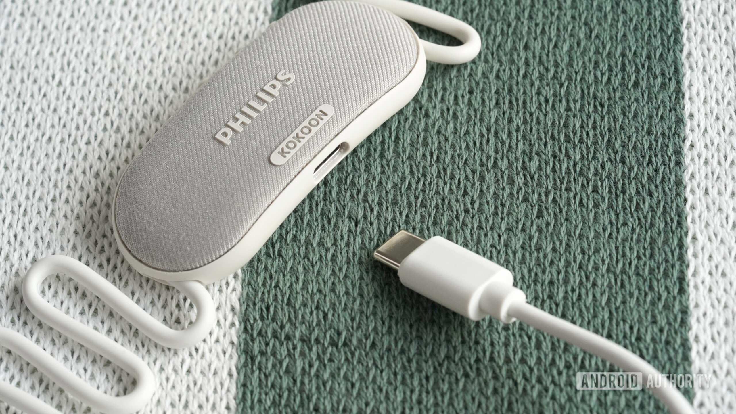 A pair of Philips Sleep Headphones rest along with a charging cable.