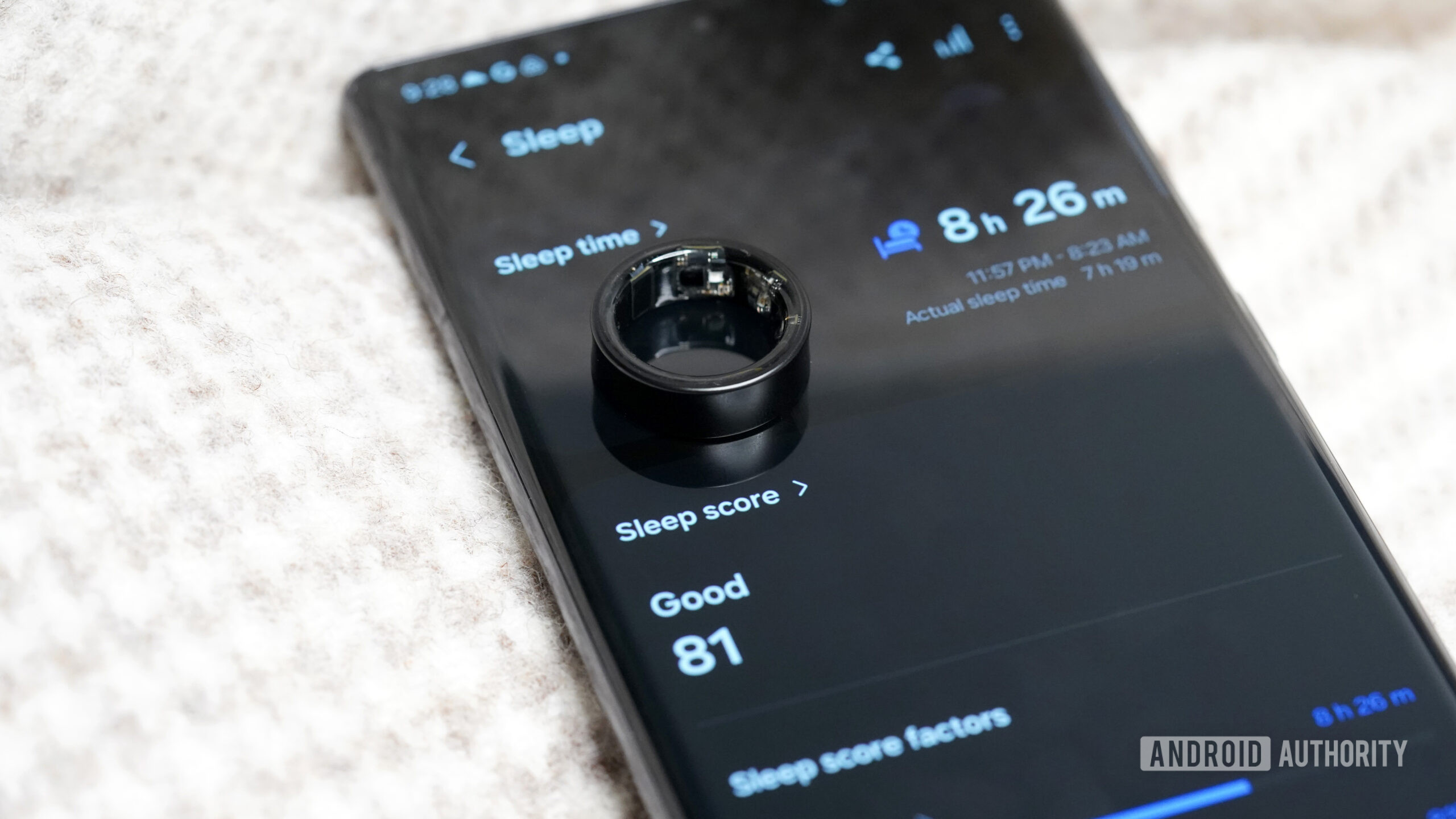 A Samsung Galaxy Ring rests on a user's sleep data displayed on their phone.