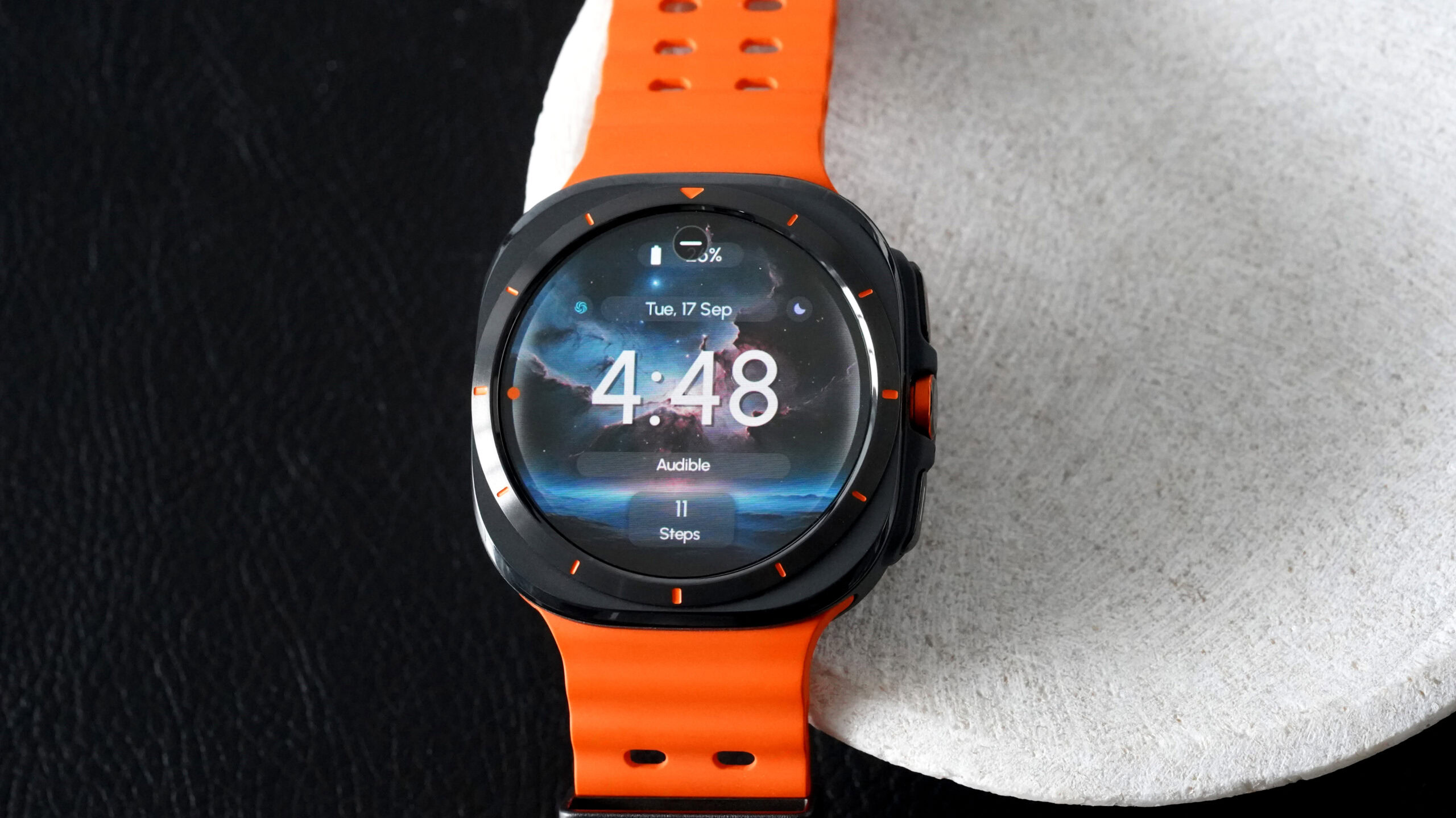 A Samsung Galaxy Watch Ultra displays the ReS25 watch face.