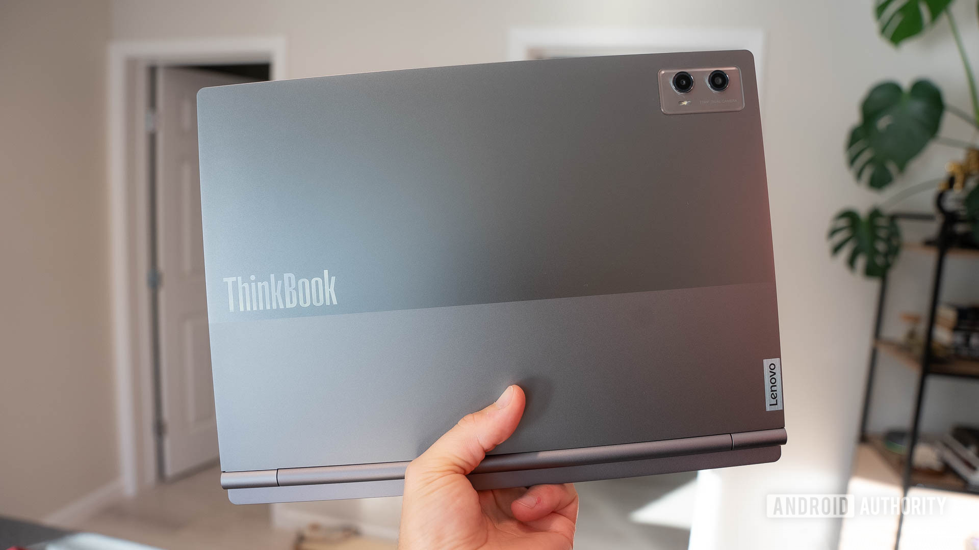 Lenovo ThinkBook Plus Gen 5 Hybrid Held Up In Hand Showing Logo