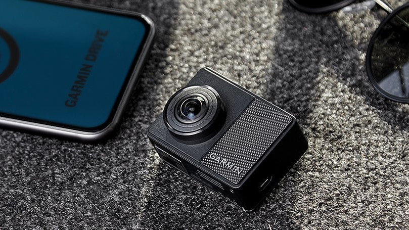 Garmin Dash Cam 67W next to glasses and phone