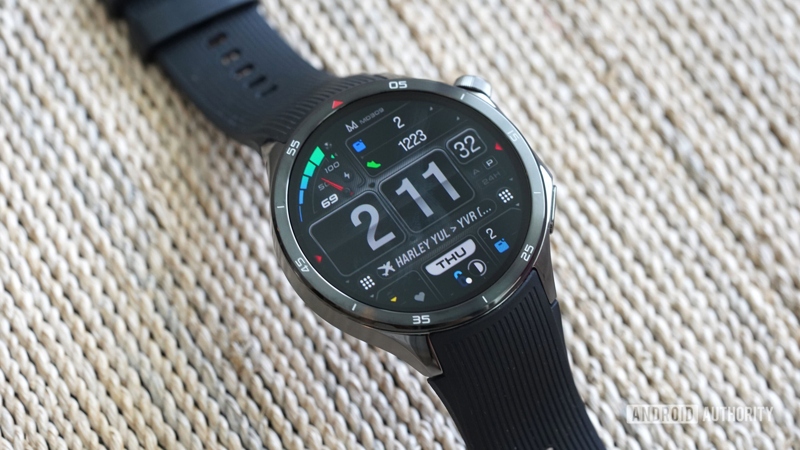 A OnePlus Watch 3 displays the MD309 Wear OS watch face.