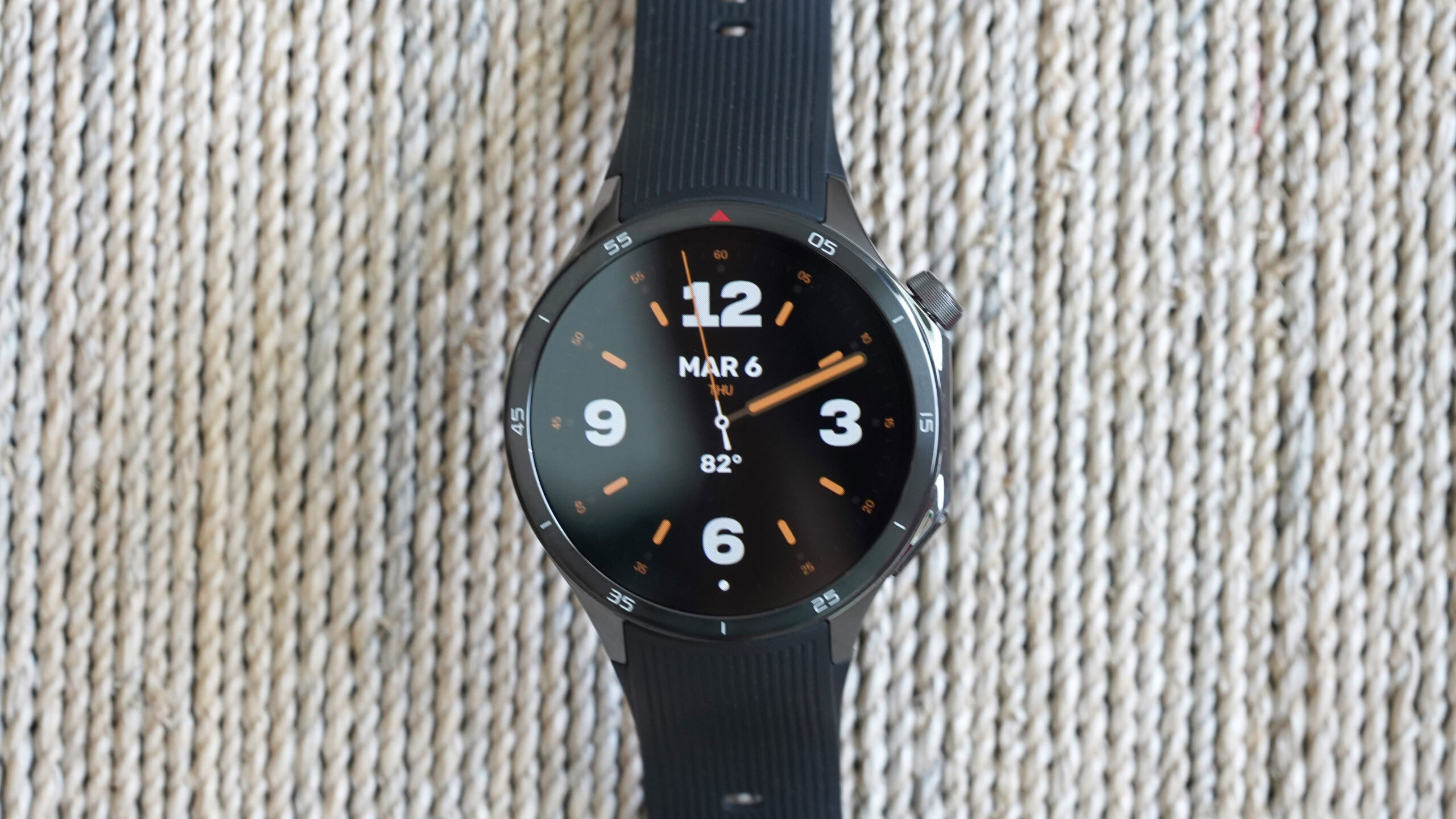 A OnePlus Watch 3 displays the Time Flies Monaco WearOS watch face